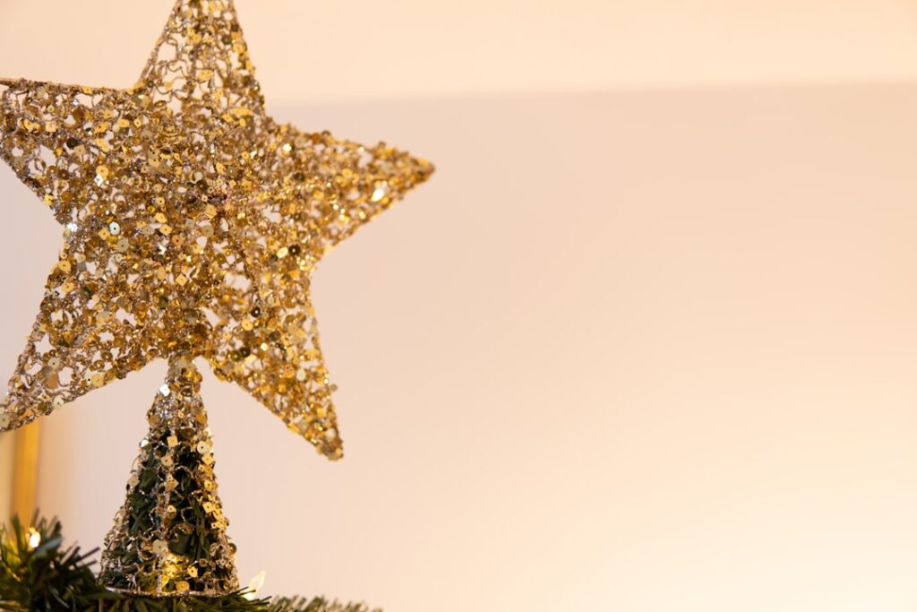 a gold star ornament hanging from a christmas tree
